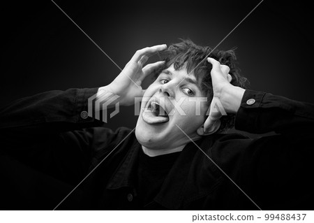 portrait of crazy young man showing the tongue. 99488437