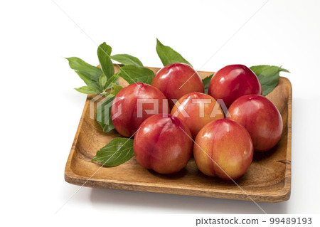 李子排列在白色背景的木板上 99489193