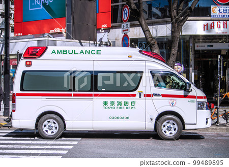 Tokyo cityscape in Japan Emergency dispatched ambulance in front of Shibuya station = Shibuya scramble crossing in front of Shibuya station 99489895