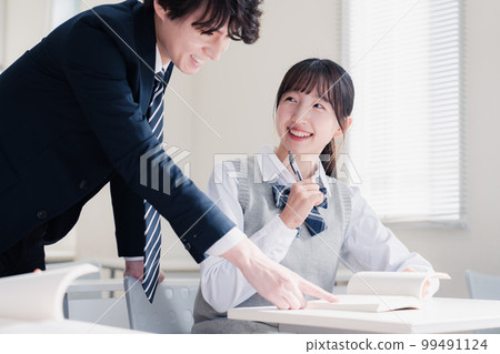 High school girl asking a question to her teacher in the classroom High school girl asking a question to her teacher in the classroom 99491124