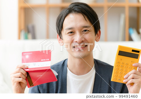 A man with a passbook and a calculator smiles A man with a passbook and a calculator smiles 99491460