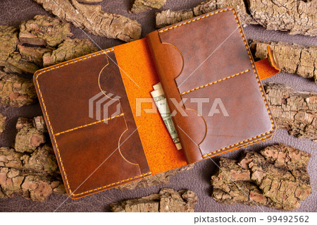 Open brown mens wallet with money and credit cards 99492562