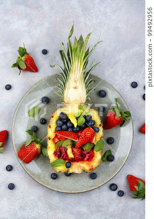 Fruit salad in half a pineapple. 99492956