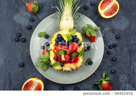 Fruit salad in half a pineapple. 99492958