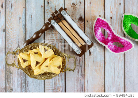 Symbols of Purim, Jewish holiday celebrating including cookies, shofar tallit, carnival masks, and hamantaschen. 99494185