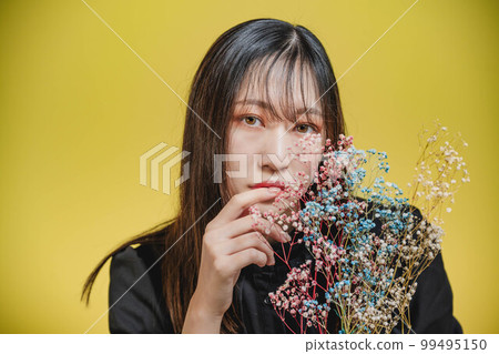 Woman in black dress with yellow background Woman in black dress with yellow background 99495150