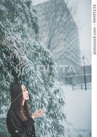 一個穿著黑色裙子、有雪和大自然的女人 99495238