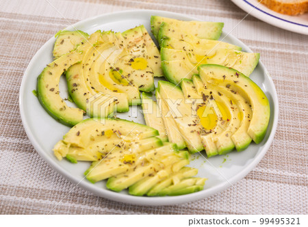 ripe avocado pulp cut into pieces sprinkled with lemon juice on a plate 99495321