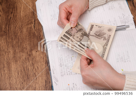 [A housewife who keeps a household account counts 10,000 yen bills] 99496536