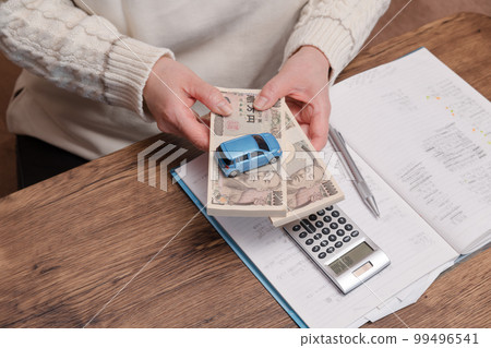 [Housewife doing calculations for buying a car] 99496541