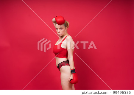 Boxer, seductive confident female boxer with gloves studio, sporty woman posing looking at camera. 99496586