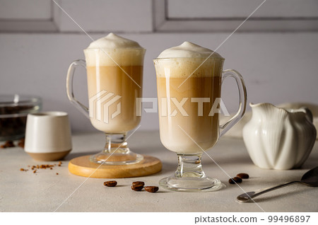 Two cups with coffee drink, latte or mocha with milk foam and cinnamon 99496897