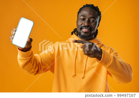 Smiling african man pointing at cellphone with blank screen with copy space Smiling african man pointing at cellphone with blank screen with copy space 99497107