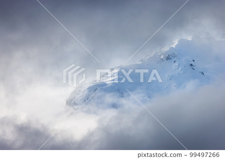 Tantalus Range covered in Snow and Clouds during Winter Season. 99497266