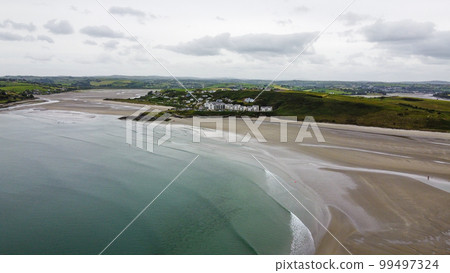Inchydoney Beach in the Ireland on a cloudy summer day, top view. Seaside landscape. The famous Irish sandy beach. The coastline of the Atlantic Ocean. Inchydoney Beach in the Ireland on a cloudy summer day, top view. Seaside landscape. The famous Irish sandy beach. The coastline of the Atlantic Ocean. 99497324