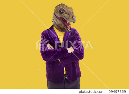 Portrait of funny extravagant man in dinosaur mask who confidently poses with folded hands. 99497869