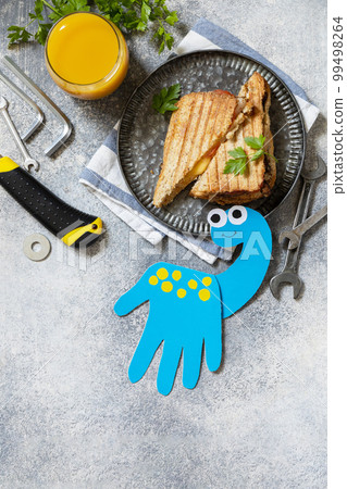 Father's day dinosaur card and breakfast for dad on gray stone table. Father's day dinosaur card and breakfast for dad on gray stone table. 99498264