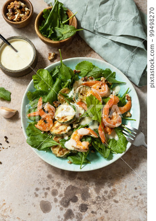 Healthy food concept. Vegetarian vegetable low carb lunch bowl. Diet salad shrimps with arugula, grilled zucchini and walnut. Copy space. Healthy food concept. Vegetarian vegetable low carb lunch bowl. Diet salad shrimps with arugula, grilled zucchini and walnut. Copy space. 99498270