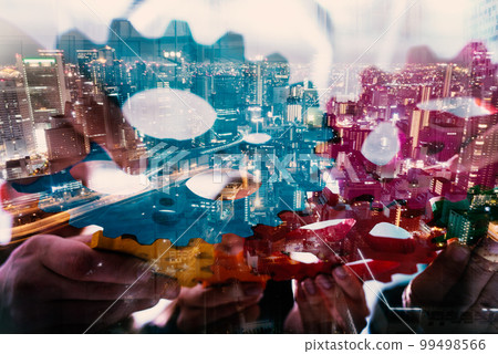 Teamwork of business people work together and combine pieces of gears 99498566
