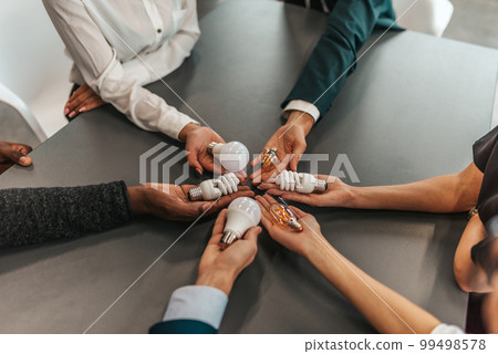 Teamwork and brainstorming concept with business people that share an idea with a lamp 99498578
