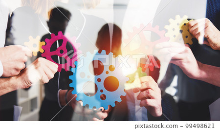 Business team connect pieces of gears. Teamwork, partnership and integration concept. double exposure Business team connect pieces of gears. Teamwork, partnership and integration concept. double exposure 99498621