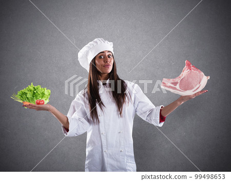 Chef undecided between fresh salad or meat steak. concept of vegetarian 99498653