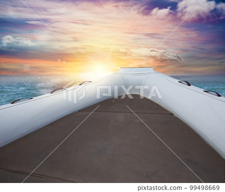 Inflatable boat at the sea during sunset Inflatable boat at the sea during sunset 99498669