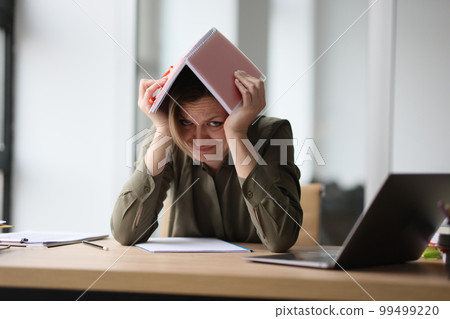 The woman in the office hid under a notebook on her head 99499220