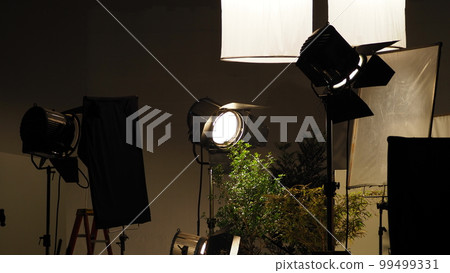 Film light for video production camera in studio set. Use as studio photo shoot light. Big LED spot light 5000w and diffuser or black panel create light like sun light can make daytime or golden hour 99499331