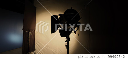 Film light for video production camera in studio set. Use as studio photo shoot light. Big LED spot light 5000w and diffuser or black panel create light like sun light can make daytime or golden hour Film light for video production camera in studio set. Use as studio photo shoot light. Big LED spot light 5000w and diffuser or black panel create light like sun light can make daytime or golden hour 99499342