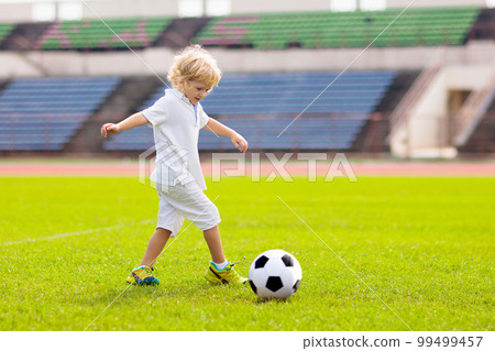 Kids play football. Child at soccer field. Kids play football. Child at soccer field. 99499457