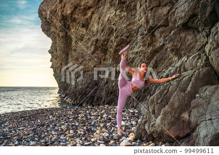 Girl gymnast is training on the beach by the sea. Does twine. Photo series Girl gymnast is training on the beach by the sea. Does twine. Photo series 99499611