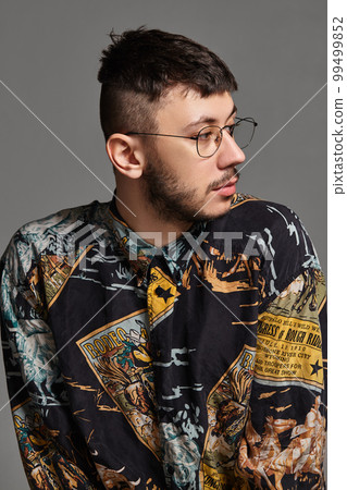 Close-up portrait of a funny guy posing in studio isolated on a gray background. 99499852