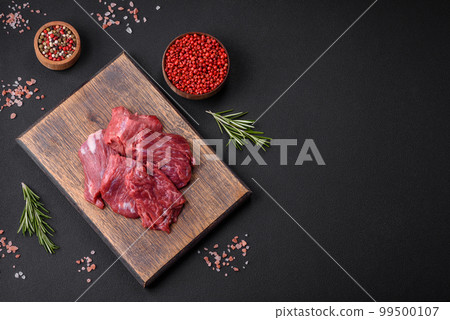 Raw beef cut into several pieces on a wooden cutting board 99500107
