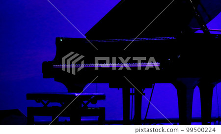A grand piano placed on the stage of a dimly lit live house before the performance 99500224
