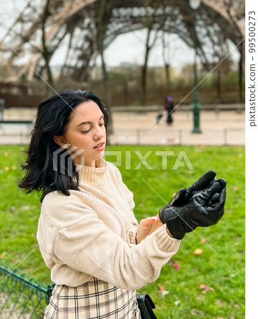 Lady near Eiffe Tower in Paris, France was made in winter. No snow, only some rain on the street. Lady near Eiffe Tower in Paris, France was made in winter. No snow, only some rain on the street. 99500273