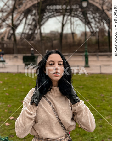 Lady near Eiffe Tower in Paris, France was made in winter. No snow, only some rain on the street. Lady near Eiffe Tower in Paris, France was made in winter. No snow, only some rain on the street. 99500287
