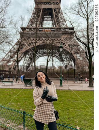 Lady near Eiffe Tower in Paris, France was made in winter. No snow, only some rain on the street. Lady near Eiffe Tower in Paris, France was made in winter. No snow, only some rain on the street. 99500288