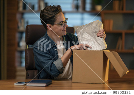 Happy young man customer got brand new laptop computer, office interior 99500321