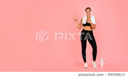 Check This. Sporty Fit Female In Wireless Headphones Pointing At Copy Space 99500623