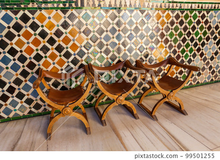 Old wooden chairs with skin (restored) at  Myrtle courtyard - Moorish art in the Alhambra  museum complex  in  Granada 99501255