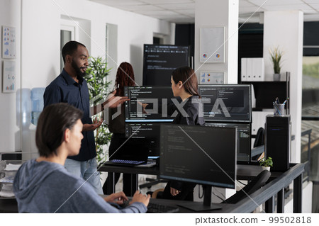 App software developer typing machine learning html code on computer, sitting at desk in it big data office. Cloud programer working on database system with coding script in software company, App software developer typing machine learning html code on computer, sitting at desk in it big data office. Cloud programer working on database system with coding script in software company, 99502818