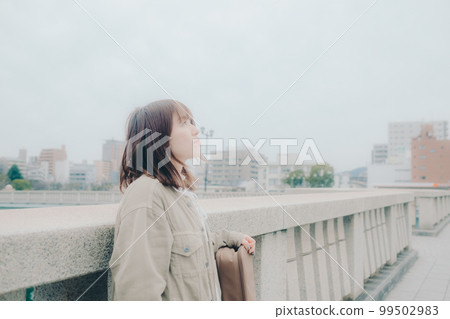 拿著吉他站在橋邊的女人的照片 99502983