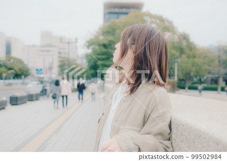 拿著吉他站在橋邊的女人的照片 99502984