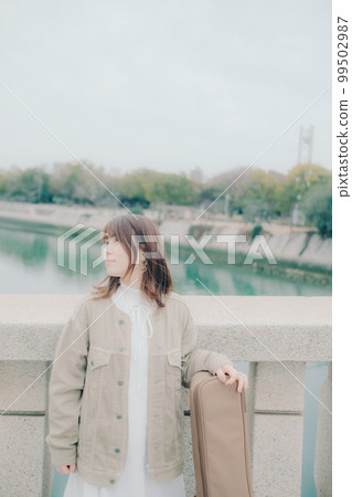 拿著吉他站在橋邊的女人的照片 拿著吉他站在橋邊的女人的照片 99502987
