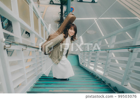 Photo of a woman holding a guitar standing on an overpass Photo of a woman holding a guitar standing on an overpass 99503076