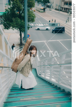 Photo of a woman holding a guitar standing on an overpass Photo of a woman holding a guitar standing on an overpass 99503077