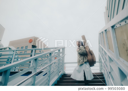 Photo of a woman holding a guitar standing on an overpass Photo of a woman holding a guitar standing on an overpass 99503080