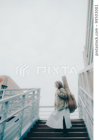 Photo of a woman holding a guitar standing on an overpass Photo of a woman holding a guitar standing on an overpass 99503081