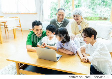 Good friends three generations family looking at a personal computer 99503490